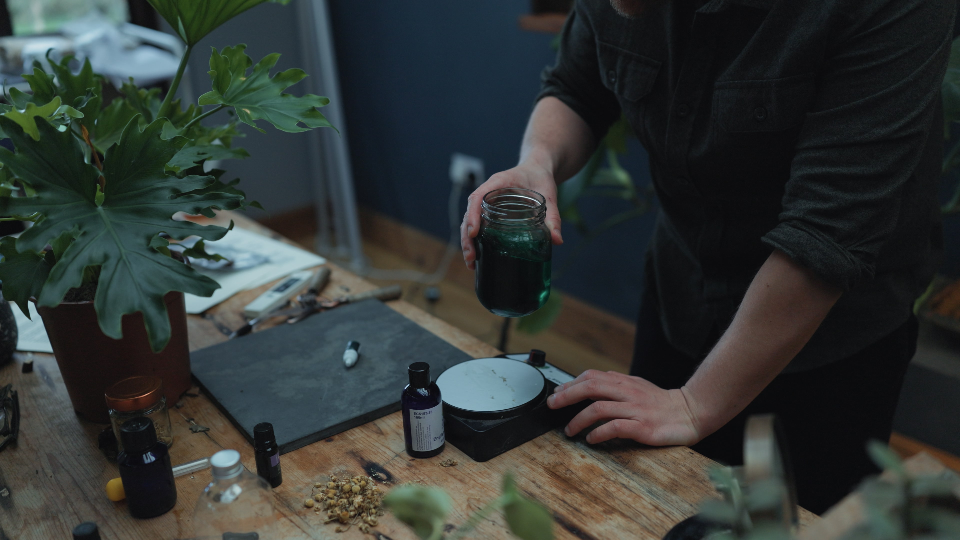 Hugo pouring a botanical tincture in the studio